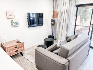 a living room with a couch and a flat screen tv at Lakeside Bliss, Perfect Location Guesthouse in Wendouree