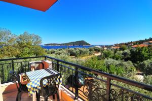 ein Balkon mit Tisch und Stühlen und Blick auf das Wasser in der Unterkunft Studios Betty in Kinira