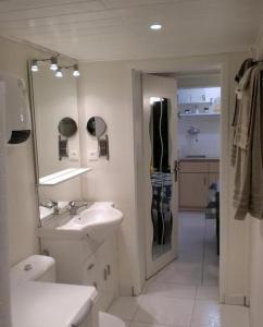 a white bathroom with a sink and a mirror at Gite du Marché d'Elsa in Kilstett