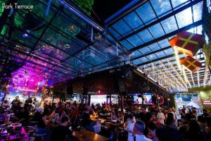 a crowd of people sitting at tables in a restaurant at The Park Residence in Bangkok +145 photos