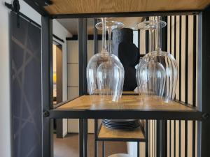drei Weingläser sitzen auf einem Regal in der Unterkunft Apartment Schlossterrassen 8a in Pouch + 29 Fotos
