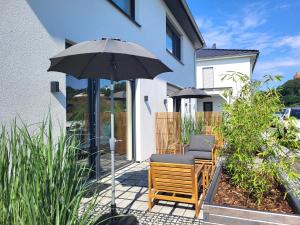 eine Terrasse mit zwei Stühlen und einem Sonnenschirm in der Unterkunft Apartment Schlossterrassen 8a in Pouch