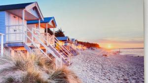 a row of beach huts on the beach at sunset at ZeitRaum Apartment in Balingen
