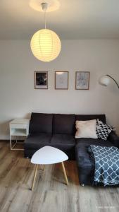 a living room with a black couch and a table at Kassel Nähe Universität und Klinikum krankenhaus in Kassel