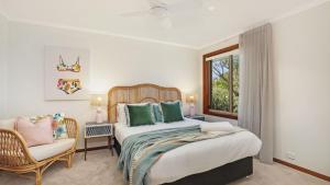 Un dormitorio con una cama y una silla y una ventana. en Coolburra, en Culburra Beach 29 fotos más