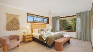 a bedroom with a bed and a chair at Coolburra in Culburra Beach