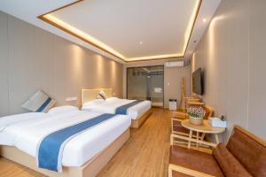 a hotel room with two beds and a couch at Floral Hotel Guilin Banxing Garden in Guilin