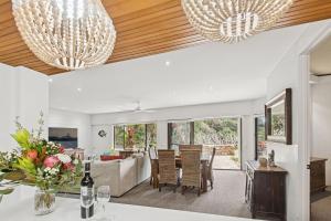 a dining room and living room with two chandeliers at Absolute Beachfront Family Villa in Kororo Basin