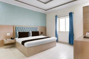 a bedroom with a large bed and a window at Super Hotel O Heera Nagar Formerly Cosy stay in Haldwāni +23 photos