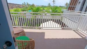 a balcony with a white railing and a table and chairs at Jasmine River Guest House in Canggu