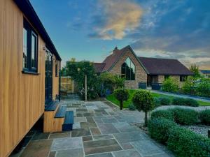 a house with a stone walkway next to a building at Dingle Dell in Great Driffield