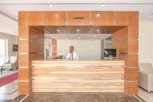 a man standing in front of a reception desk at Super Hotel O Ivy Dew Drops in Bengaluru +26 photos