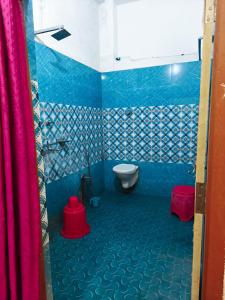 a bathroom with a toilet and blue and white tiles at Hotel Parinay Vatika - Deoghar in Deoghar