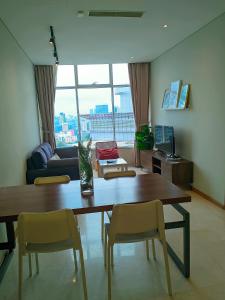 Una sala de estar con una mesa y sillas de madera. en Sky Suite KLCC By iran, en Kuala Lumpur