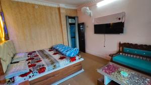 a bedroom with a bed and a flat screen tv at Lohaghat View Homestay in Lohaghāt