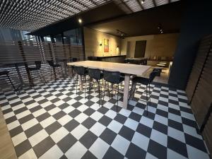 Zimmer mit einem Tisch und Stühlen auf einem karierten Boden in der Unterkunft Oceana Suites San Eugenio, Ñuñoa in Santiago