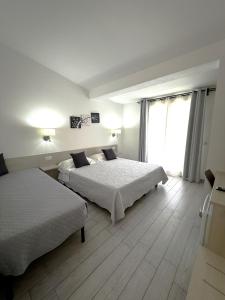 a bedroom with two beds and a large window at Bentus B&B in Villasimius