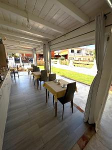 a dining room with tables and chairs and a large window at Bentus B&B in Villasimius
