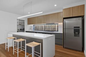 a kitchen with a white counter and a refrigerator at Wirilda Seaside Escape in Inverloch