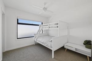 a white bunk bed in a white room with a window at Wirilda Seaside Escape in Inverloch +16 photos