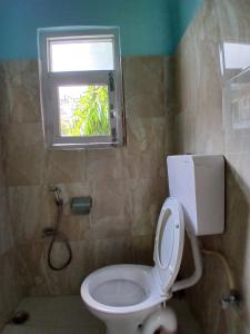 une salle de bain avec toilettes et fenêtre dans l'établissement Hotel Unicorn, à Pokhara 9 autres photos