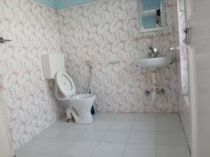 une salle de bains avec toilettes et lavabo dans l'établissement Hotel Unicorn, à Pokhara