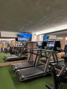 a gym with a bunch of treadmills and computers at WX Hotel in Bratislava