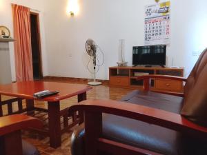 阿努拉德普勒Ranmini Family Resort的客厅配有桌子和风扇