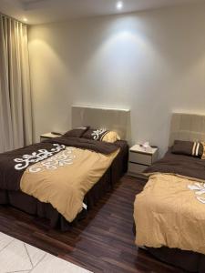 two beds sitting next to each other in a bedroom at شقة مفروشة أنيقة للإيجار اليومي في مكة -الشرائع in Ash Sharāʼi‘