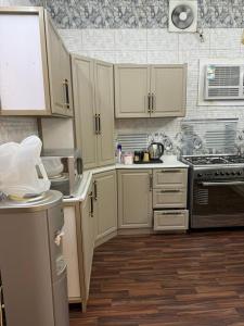 a kitchen with white cabinets and a stove top oven at شقة مفروشة أنيقة للإيجار اليومي في مكة -الشرائع in Ash Sharāʼi‘
