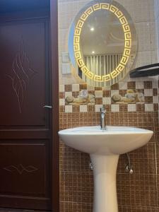 a bathroom with a sink and a mirror at شقة مفروشة أنيقة للإيجار اليومي في مكة -الشرائع in Ash Sharāʼi‘