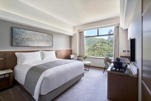a hotel room with a large bed and a window at Hopewell Hotel in Hong Kong
