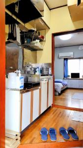 a kitchen with two pairs of slippers on the floor at Kokusaigakusya Ozukikaikan - Vacation STAY 17326 in Hadano +14 photos