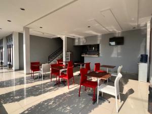a dining room with red chairs and a table at OYO 94785 Diana Homestay Syariah in Sunggal