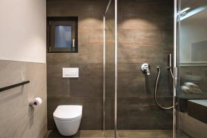 a bathroom with a toilet and a glass shower at Villa Erina in Ortisei +44 photos