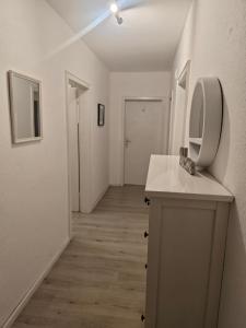 a white bathroom with a sink and a mirror at Work and Stay Plettenberg 6 Betten Dusche Küche Balkon Garten in Plettenberg