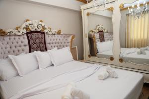 a bedroom with a white bed and a mirror at Said's Luxury Apartment in Berat