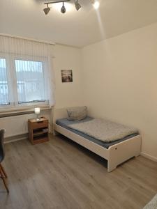 a small bedroom with a bed and a night stand at Work and Stay Plettenberg 6 Betten Dusche Küche Balkon Garten in Plettenberg