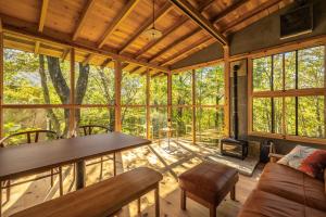 a living room with a table and chairs in a house at KIZUKI 子供の記憶にいつまでも思い出が残る場所 虫も天気も気にせず屋内bbq 遊具 大浴場 in Nasu