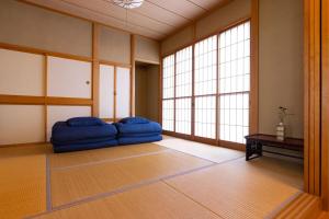 a room with a large blue couch in a room with windows at KIZUKI 子供の記憶にいつまでも思い出が残る場所 虫も天気も気にせず屋内bbq 遊具 大浴場 in Nasu +46 photos