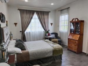 a bedroom with a bed and a chair and a window at El Aposento Alto in La Paz