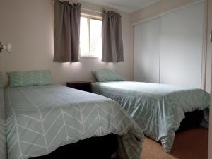 1 Schlafzimmer mit 2 Betten und einem Fenster in der Unterkunft Lake Barra Cottages in Downsfield