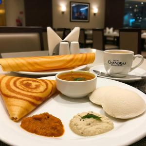a plate with soup and bread and a cup of coffee at Hotel Chandraa Celebration ISBT Dehradun in Dehradun +39 photos