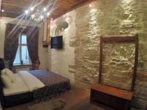 a bedroom with a bed and a stone wall at Viru Lux Apartment in Tallinn
