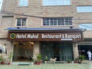 a hotel manifold restaurant and banquet sign in front of a building at Hotel Mahal in Uchalon