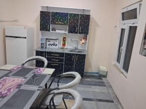 a small kitchen with a table and a refrigerator at Adashboy Palace Family Guest House in Samarkand +14 photos