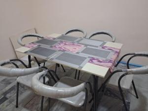 a table with four chairs and a table with a quilt on it at Adashboy Palace Family Guest House in Samarkand
