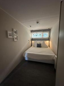 a bedroom with a white bed with a window at Schwarzwaldloge Zeitlos in Brandmatt