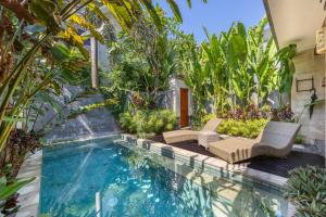 a swimming pool with chairs and trees in a house at Cove Belle Asana in Canggu