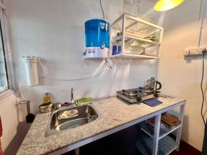 a kitchen with a sink and a stove at Varma Brick House in Manipal